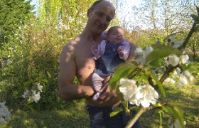 Papa me montre les fleurs dans les arbres du jardin